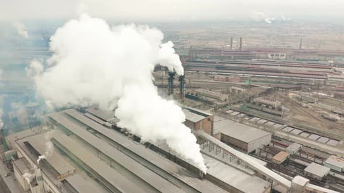 Zona industrial con una gran pipa roja y blanca Se vierte humo blanco espeso de la tubería de fábrica