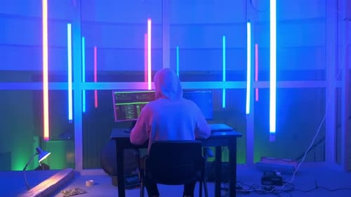 Un hacker criminel travaillant le soir sur un ordinateur dans un grand bureau