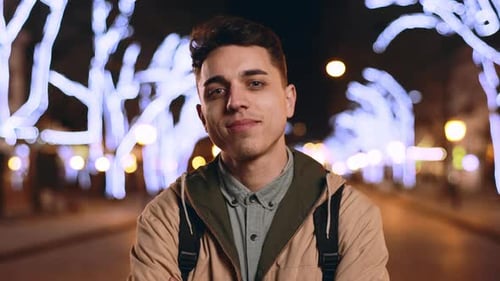 Portrait of Young Cheerful Man 20s Smiling While Strolling in Evening City Across Main Avenue with