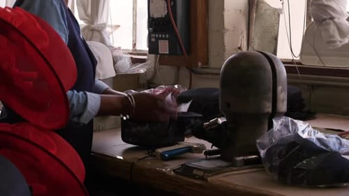 Mixed race woman working at a hat factory