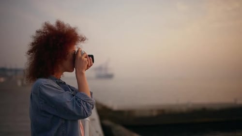 Young Adult Photographing the Ocean at Sunset