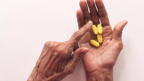 Senior Women Hand's Taking Medicine, Close Up