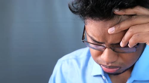 Adult with Glasses and Hand to Forehead