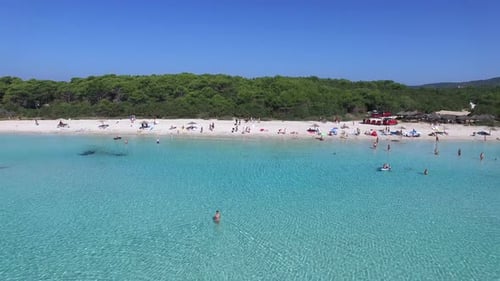 People swimming and sunbathing on a mediterranean beach