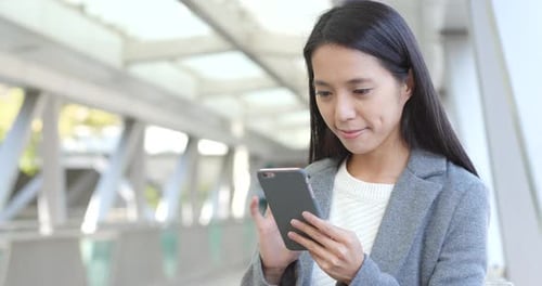 Woman Using Voice Command on Mobile Phone Outdoors