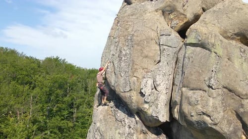 Strong Male Climber Climbing Steep Wall of Rocky Mountain