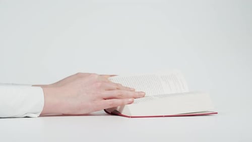 Hands Turn Pages in a Book