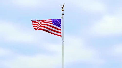 American Flag Waving Against Blue Cloudy Sky