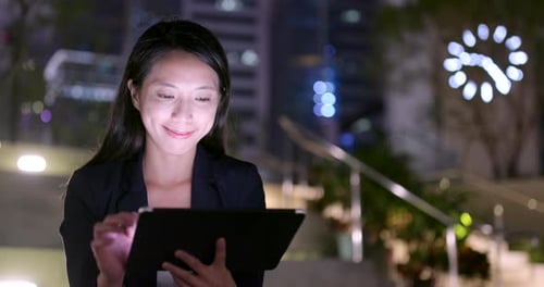 Woman Using Tablet at Night in City