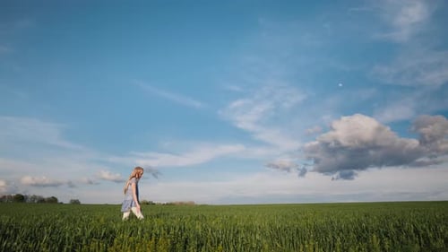 Side View: A Girl Walks Along the Picturesque Floor in the Rays of the Setting Sun
