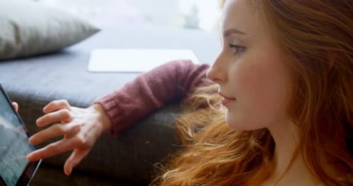 Woman Relaxing Indoors with Tablet Device