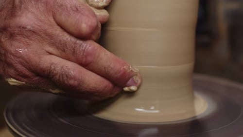 Potter amincit les murs de verre en utilisant le tour de potier