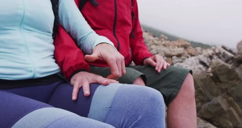 Affectionate Couple Holding Hands on Rocky Beach