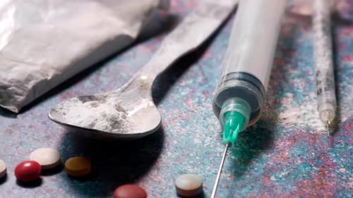 Drug Addiction Concept with Heroine Packet and Syringe on Black Backgrund