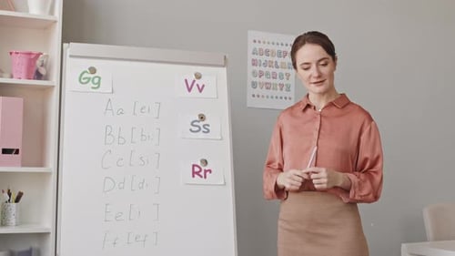 Woman Explaining the Alphabet in Classroom Setting