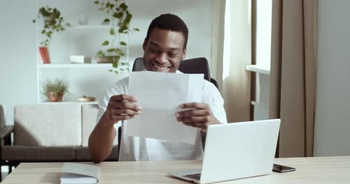Casual African Guy Student Happy Business Man Reading Document Paper Notice Letter From Bank or