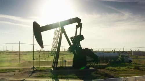 Ölpumpenheber mit grüner Landschaft auf ländlichem Hintergrund Ölindustrie