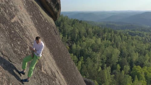A Young Man Descends From a Rock Mountain on a Rope.
