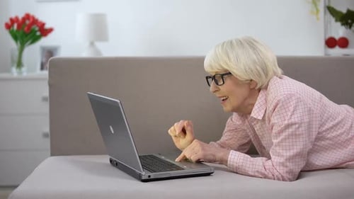 Senior Woman Using Laptop Computer on Couch