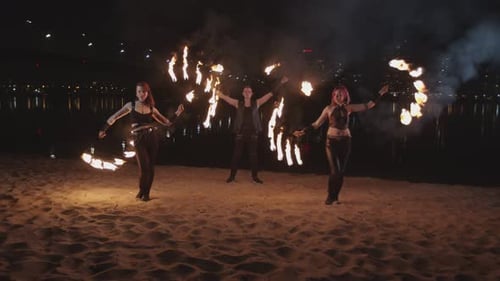 Young Fireshow Artists Juggling Flame Near River