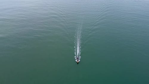 Aerial view from a drone of Thai traditional longtail fishing boats sailing in the sea.