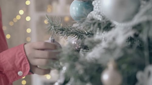 Child Decorating Christmas Tree with Bauble Ornaments
