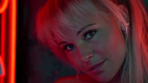 Sexy Blonde Woman in Nightclub at Night, Closeup Portrait, Looking at Camer and Smiling, Flirting