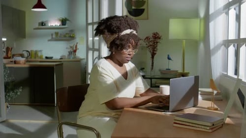 Woman Typing on Laptop at Desk at Home