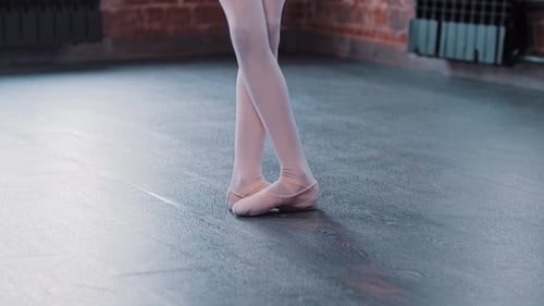 A Ballerina Girl Training in a Dance Studio Feet in the Position