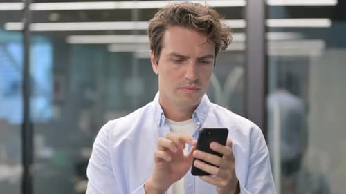 Young Adult Using Smartphone Indoors