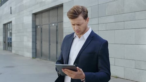 Businessman Working on Digital Tablet in City. Manager Browsing Internet on Pad