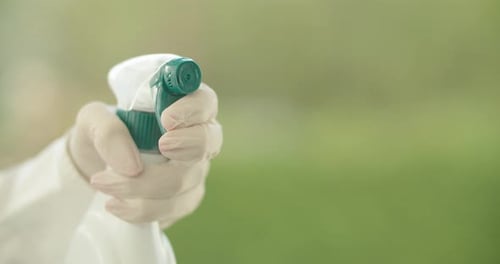 Spraying Disinfectant From Bottle in Gloved Hand