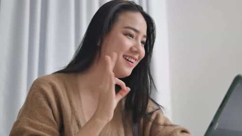 Woman Smiles During Online Video Call at Home