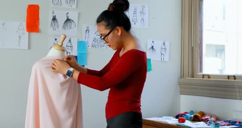 Female Designer Pins Fabric on Dress Form