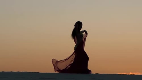Silhouette Woman Dancing in the Desert at Sunset