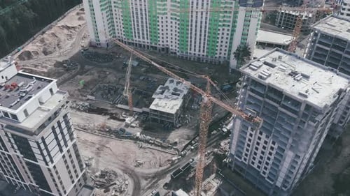 Moderne Wohnhochhausanlage im Bau mit riesigen Kränen, Drohnenblick aus der Luft.