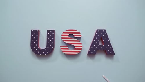 Gemaltes USA-Schild mit Weiß, Rot und Blau auf blauem Hintergrund.