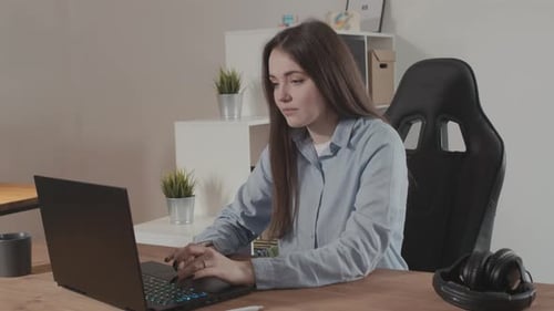 Girl in a Modern Office Working on a Laptop