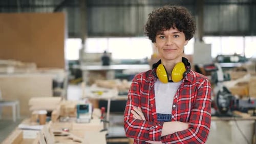 Confident Woman Carpenter Stands Proudly in Workshop