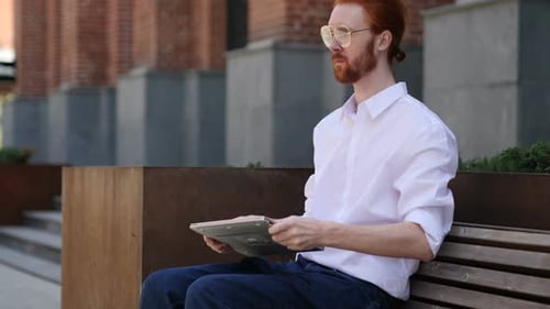 Designer geht, nachdem er auf der Bank gesessen und am Laptop gearbeitet hat