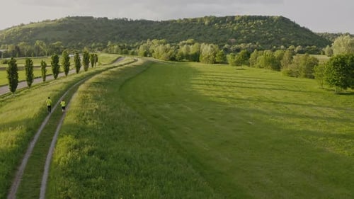 Couple Jogging on a Scenic Green Trail