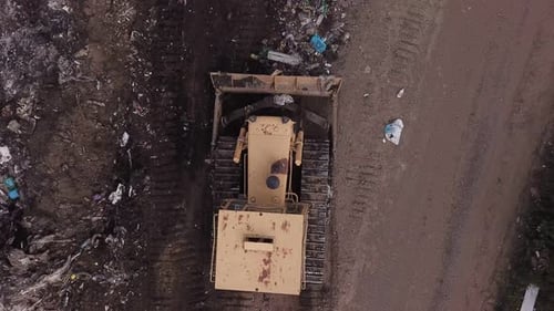 Bulldozer Moves Garbage at Landfill from Above