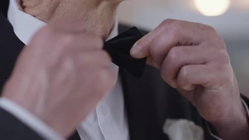 Man in Tuxedo Adjusting Black Bow Tie