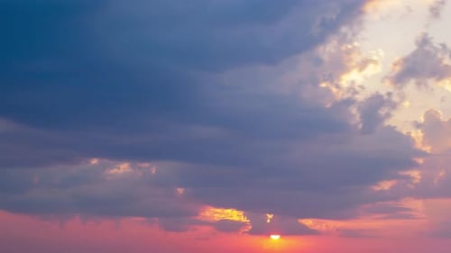 Time lapse of a beautiful scenic red sunset over the city with the sun shining through the dramatic