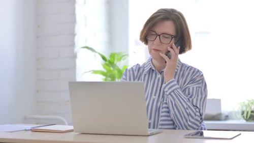Woman Talking on Cell Phone in Bright Office