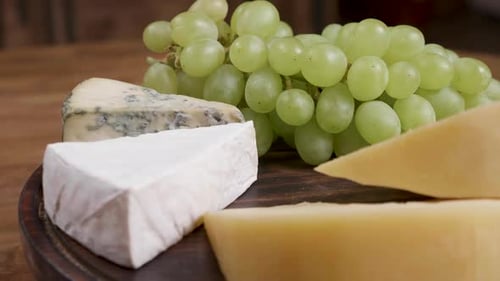 Cheese and Grapes on a Wooden Board