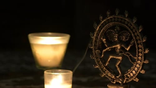 Candlelight Illuminating Religious Statue in a Dark Room