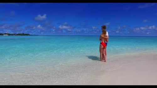 Guy and girl sunbathing on perfect seashore beach holiday by turquoise water and white sand backgrou
