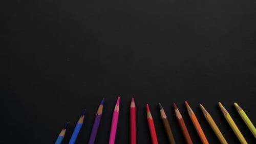 Wooden School Pencils of Different Colors Are Located on the Black Surface. Stop Motion Animation