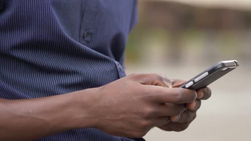 Youth, devices, communication- young black man's hands typing on smart phone